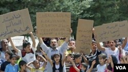 Para pengungsi Suriah di Turki melakukan unjuk rasa dengan membawa poster 'Lindungi Jisr al-Shughour dari Bashar al-Assad' (10/6).