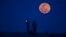 FILE - A man takes a picture of the moon rising during a lunar eclipse, in a suburb of Shanghai, April 15, 2014. 