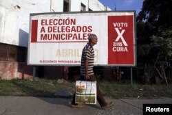 A man walks past near a poster announcing Cuba's municipal elections, to be held April 19, in Havana, Cuba, April 6, 2015.