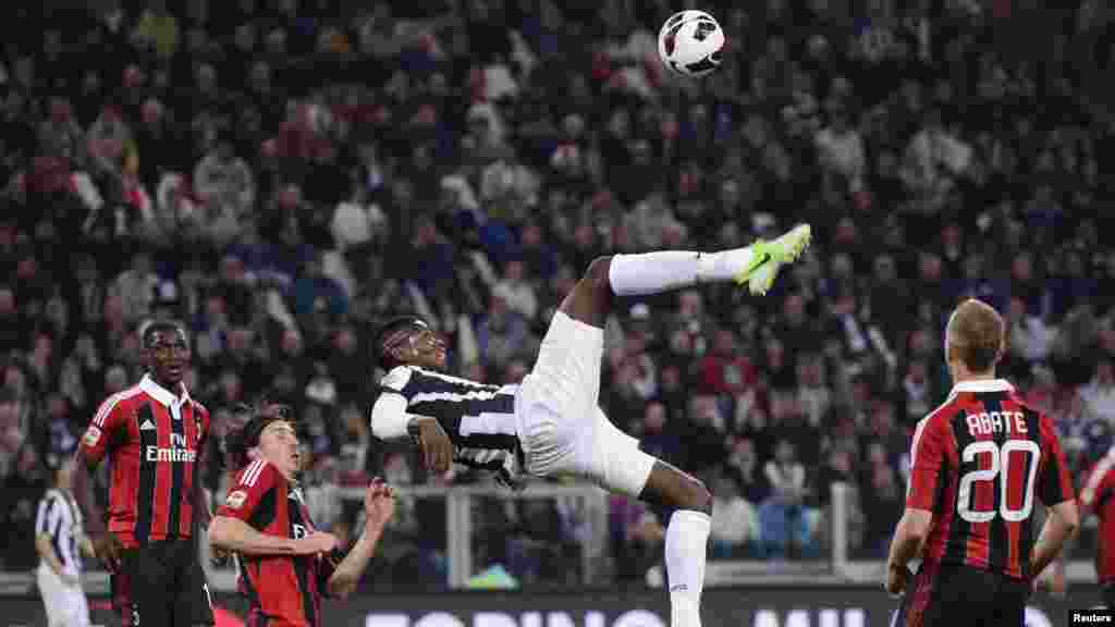 Juventus' Paul Pogba (C) kicks the ball during their match against AC Milan in their Serie A soccer match at Juventus stadium in Turin April 21, 2013.