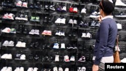 FILE - A woman shops inside a Foot Locker store in New York, May 28, 2010. 
