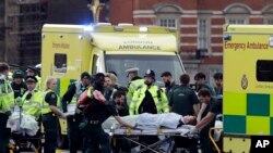 Emergency services transport an injured person to an ambulance, close to the Houses of Parliament in London, March 22, 2017.