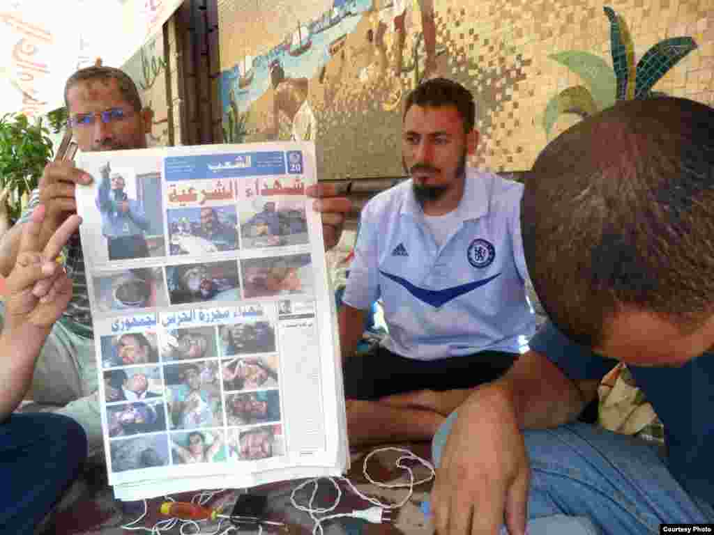 Các bác sĩ nhóm Huynh đệ Hồi Giáo trưng ra tờ báo có hình những người ủng hộ họ bị giết trong một cuộc đối đầu với quân đội Ai Cập 8-7-2013. Ảnh: VOA/Sharon Behn