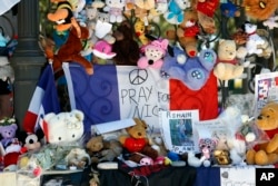 Dolls and teddy bears are placed at a memorial in a gazebo on the Promenade des Anglais in Nice, southern France on July 20, 2016.