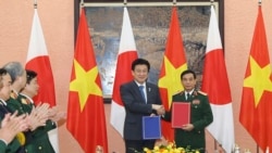 Menteri Pertahanan Jepang Minoru Kihara (kedua dari kanan) dan Menteri Pertahanan Vietnam Phan Van Giang (kanan), bertukar dokumen yang ditandatangani di Hanoi, Vietnam, Selasa, 6 Agustus 2024. (Nguyen Trong Duc/VNA via AP)