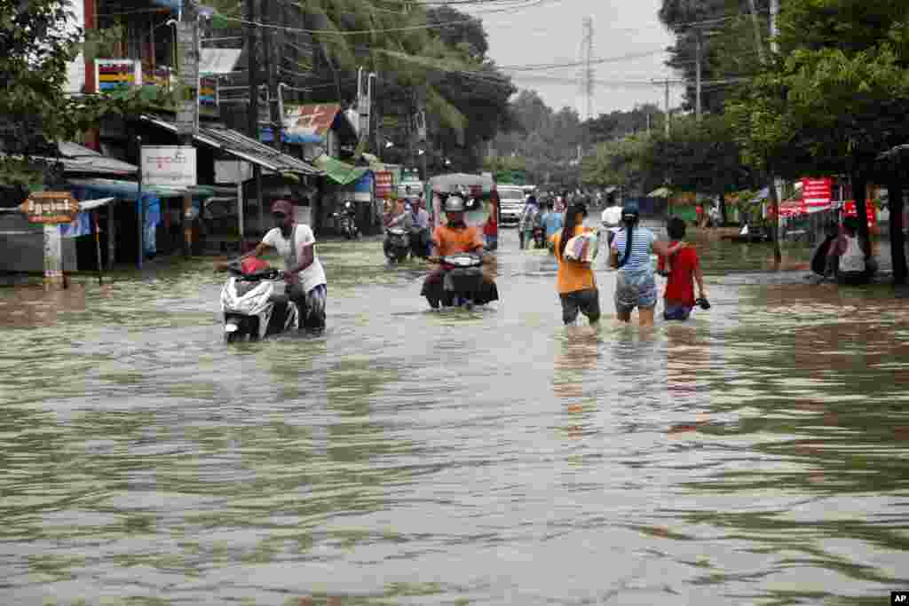 Local residents wade through a flooded road in Bago, 80 kilometers (50 miles) northeast of Yangon, Myanmar, Aug 1, 2015.