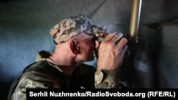 Український військовий дивиться у бінокль на позиції біля Станиці Луганської на сході України (ілюстраційне фото)