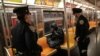 Pripadnici njujorške politicje bude putnika u vozu njujorškog metroa. Podzemna železnica je, prvi put u istoriji, planski zatvorena zbog detaljnog čišćenja, 6. maja 2020. 