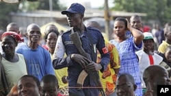 An Ivory Coast policeman stands guard during a youth rally in Abidjan, Ivory Coast, Dec 20, 2010