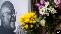 Tampak bunga-bunga ditaruh di samping foto dari Uskup Agung Desmond Tutu di Gereja Katedral St. George di Cape Town, South Africa, pada 26 Desember 2021. Tutu meninggal dunia pada usia 90 tahun.