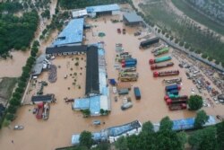 Bangunan dan kendaraan yang terendam banjir akibat hujan lebat di kawasan Shexian, kota Huangshan, provinsi Anhui China bagian timur, 7 Juli 2020.