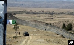 FILE - Pakistani soldiers stand guard at a newly erected fence between Pakistan and Afghanistan at Angore Adda, Pakistan, Oct. 18, 2017.