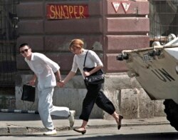 A young couple runs across the infamous Sniper Alley in Sarajevo in this 1995 file photo. Slobodan Milosevic, branded the "butcher of the Balkans" for the wars that tore Yugoslavia apart in the 1990s, was found dead in his cell on March 11, 2006, just mon