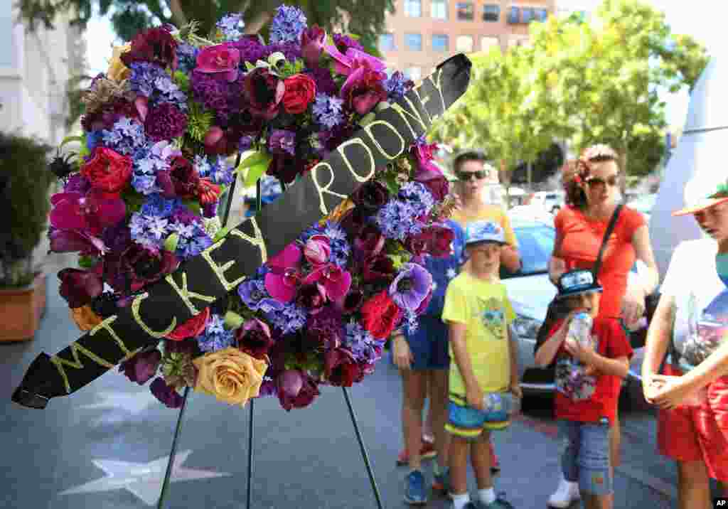 Tourists from Australia stand by a memorial wreath on the Hollywood Walk of Fame star of Hollywood legend, Mickey Rooney, on Vine Street, April 7, 2014, in Los Angeles. 