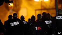 French police officers gather outside a high school after a history teacher who opened a discussion with students on caricatures of Islam's Prophet Muhammad was beheaded, in Conflans-Saint-Honorine, north of Paris, Oct. 16, 2020.