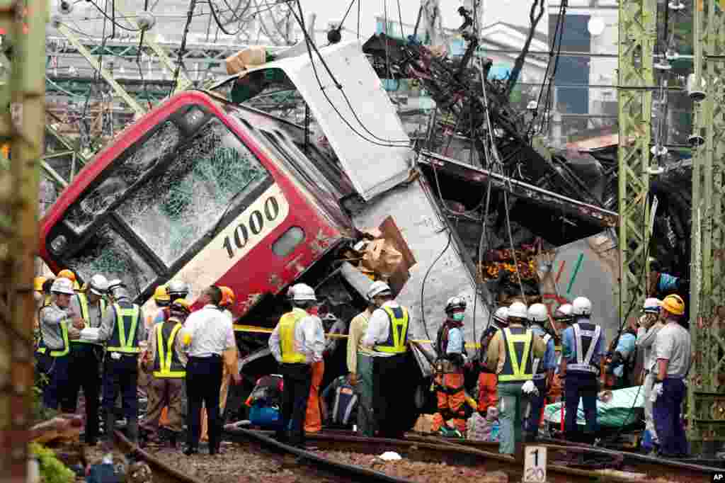 The Keikyu express train sits derailed after its collision with a truck in Yokohama, south of Tokyo, Japan. The commuter train and a truck loaded with boxes of citrus collided at a rail crossing near Tokyo, injuring dozens of people, authorities said.