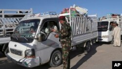 Iraqi security forces check identification documents at a checkpoint near the entrance to Ramadi, 70 miles (115 kilometers) west of Baghdad, April 3, 2016. 