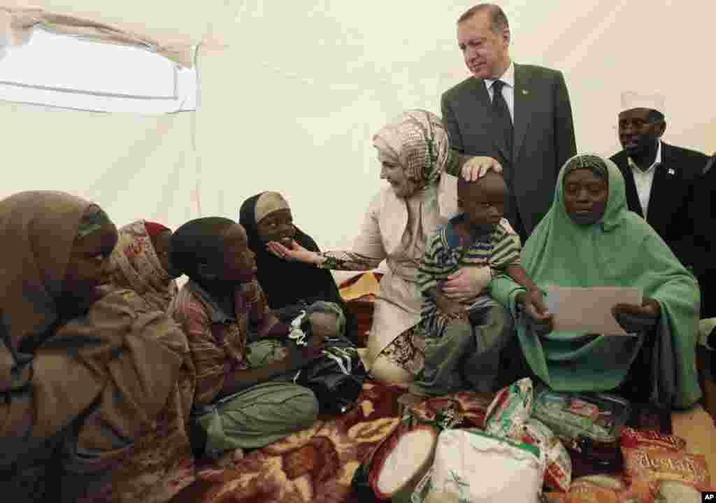 Turkey's Prime Minister Recep Tayyip Erdogan (top) and his wife Emine Erdogan (C) visit a camp for displaced people as they are accompanied by Somalia's President Sheikh Sharif Ahmed (R) in Mogadishu August 19, 2011. Erdogan and his family visit Somalia, 