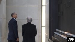 U.S. President Barack Obama (L) looks back at a wall featuring the names of former World War II concentration camps after lighting candles with Nobel Laureate and Holocaust survivor Elie Wiesel in the Remembrance Hall at the United States Holocaust Museum