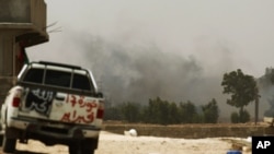 Smoke rises after a rocket exploded near a Libyan rebel fighter position on the outskirts of Zlitan near Misrata's western front line