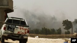 Smoke rises after a rocket exploded near a Libyan rebel fighter position on the outskirts of Zlitan near Misrata's western front line