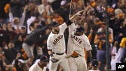 Los jugadores de los Gigantes, Brandon Belt y Pablo Sandoval, chocan cinco en el aire, tras derrotar a los Nacionales de Washington.