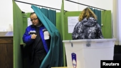 A Slovenian couple votes during the second round of presidential elections at a polling station in Planina, December 2, 2012.