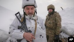 Ukrainian servicemen stand in a trench on the front line in the Luhansk area, eastern Ukraine, Jan. 27, 2022.