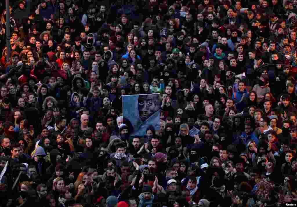 People attend a gathering to protest against the death of a street hawker in central Madrid, Spain.