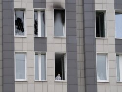 Seorang anggota staf medis (bawah) melihat melalui jendela terbuka di dekat lokasi kebakaran di Rumah Sakit St. George, St. Petersburg, Rusia, Selasa, 12 Mei 2020.