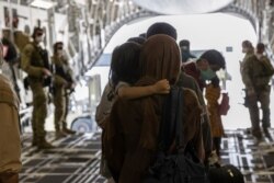 In this image provided by the Australian Defense Force on Aug. 22, 2021, Afghanistan evacuees arrive at Australia's main operating base in the Middle East, on board a Royal Australian Air Force C-17A Globemaster.