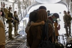 In this image provided by the Australian Defense Force on Aug. 22, 2021, Afghanistan evacuees arrive at Australia's main operating base in the Middle East, on board a Royal Australian Air Force C-17A Globemaster.