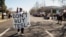 People protest against Tesla and Elon Musk outside of a Tesla dealership in Palo Alto, California, on March 8, 2025. U.S. President Donald Trump said on March 11 he would buy a Tesla vehicle as a show of support as the company becomes a focal point of protests against Musk.