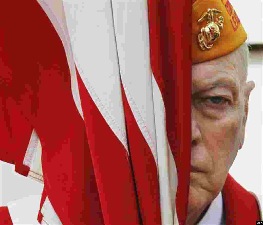Veteran Robert Flick holds an American flag during a Veteran�s Day ceremony attended by President Barack Obama Friday, Nov. 11, 2011, at Arlington National Cemetery in Arlington, Va. (AP Photo/Pablo Martinez Monsivais)