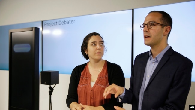 Noa Ovadia, left, and Dan Zafrir, right, prepare for their debate against the IBM Project Debater, Monday, June 18, 2018, in San Francisco. (AP Photo/Eric Risberg)