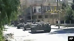 This image made from amateur video released by Deir el-Zour Press news and accessed via The Associated Press Television News, shows Syrian tanks on the street in Deir el-Zour, Syria, August 9, 2011