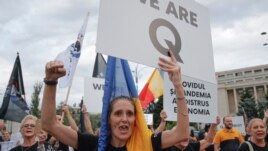 Romanian supporters of QAnon shout slogans against the government's measures to prevent the spread of the COVID-19 infections, like wearing a face mask, during a rally in Bucharest, Romania, Monday, Aug. 10, 2020.(AP/Vadim Ghirda)