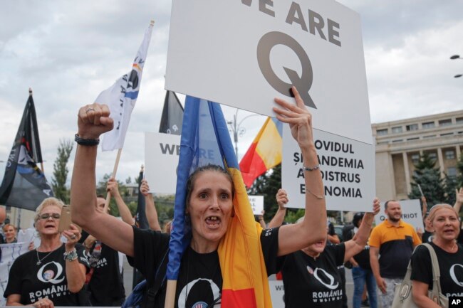 Romanian supporters of QAnon shout slogans against the government's measures to prevent the spread of the COVID-19 infections, like wearing a face mask, during a rally in Bucharest, Romania, Monday, Aug. 10, 2020.(AP/Vadim Ghirda)