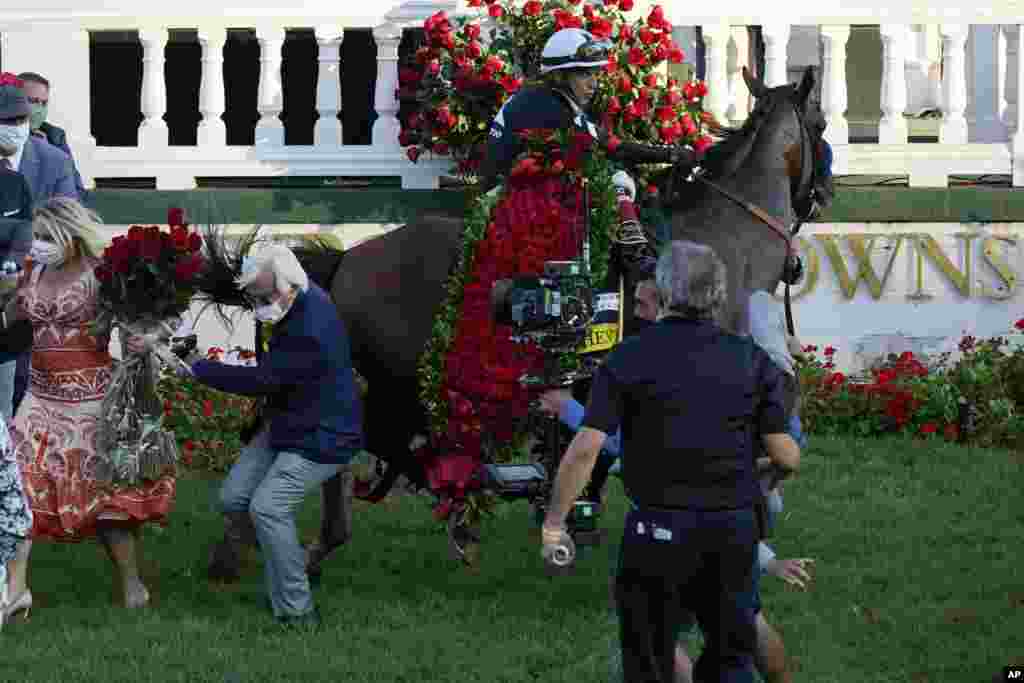 Trainer Bob Baffert is knocked to ground as Jockey John Velazquez try to control Authentic in the winners&#39; circle after winning the 146th running of the Kentucky Derby at Churchill Downs, Sept. 5, 2020, in Louisville, Kentucky.