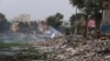 A homeless person burns garbage in the polluted river Cooum in Chennai in southern Indian state of Tamil Nadu, July 20, 2019.