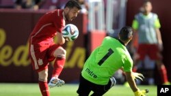 David "El guaje" Villa toca un balón que superara al arquero salvadoreño, Derby Carrillo, en el juego que España derrotó a El Salvador, 2 a 0, en el FedexField de Washington.