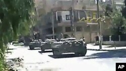 This image made from amateur video released by Deir el-Zour Press news and accessed via The Associated Press Television News, shows Syrian tanks on the street in Deir el-Zour, Syria, Tuesday August 9, 2011