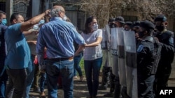 El periodista Carlos Fernando Chamorro es empujado por policías antimotines en Managua, cuando intentó ingresar a sus oficinas, las cuales siguen intervenidas por el gobierno.
