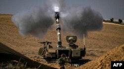 EDITORS NOTE: Graphic content / TOPSHOT - An Israeli army M109 155mm self-propelled howitzer fires rounds toward the Gaza Strip from a position in southern Israel across the border on October 28, 2023.