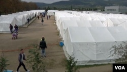 Migrants and asylum-seekers are seen walking on the grounds of the make-shift reception center in Traiskirchen, Austria. (Photo - VOA video grab)