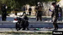 FILE - Afghan security forces inspect the site of a suicide attack in Kabul, Afghanistan Sept. 9, 2018.