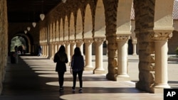 FILE - Students walk on the Stanford University campus, March 14, 2019, in Santa Clara, Calif.