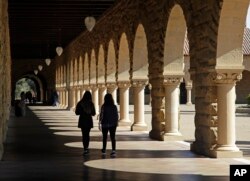 FILE - Students walk on the Stanford University campus, March 14, 2019, in Santa Clara, Calif.