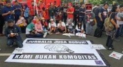 Para Jurnalis dari Aliansi Jurnalis Independen (AJI) Surabaya mengikuti aksi pada Hari Buruh di Surabaya (Foto:VOA/Petrus Riski).
