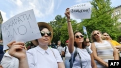 FILE - An activist holds a placard reading 'Punish evil!' (L) during a protest in front of the Ukrainian Ministry of Internal Affairs in Kiev on August 1, 2018, a day after a shocking acid attack on civil activist Kateryna Gandzyuk.